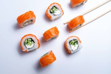 Suşi dilimleri beyaz arkaplanda düzgün bir şekilde dizilmiş.