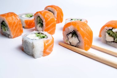 Beyaz arka planda düzgün sıralanmış suşi dürümleri.