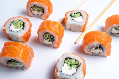 Dilimlenmiş suşi dürümleri, yakınlarda yemek çubukları var.