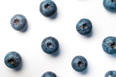 Beyaz arkaplana dağılmış taze yaban mersinleri