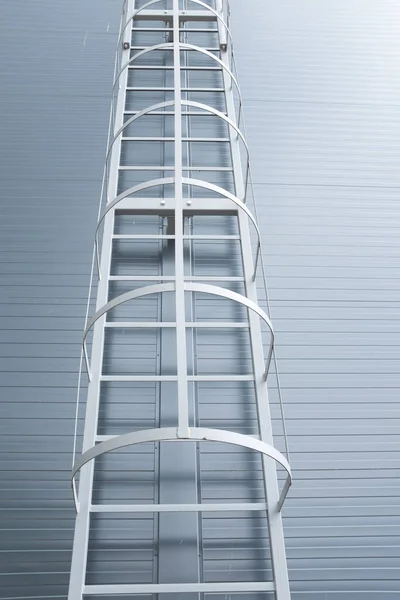 Gri endüstriyel yapı duvarına dayanan metal merdiven