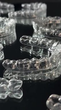 Siyah arka planda görünmez ortodonti kozmetik parantez. Güzel bir gülümseme için diş hizalayıcıları. Bu görünmez hizalayıcı, dişinin görünüşüne ve özgüvenine modern bir yaklaşım sergiliyor.. 