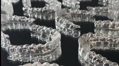 Siyah arka planda görünmez ortodonti kozmetik parantez. Güzel bir gülümseme için diş hizalayıcıları. Bu görünmez hizalayıcı, dişinin görünüşüne ve özgüvenine modern bir yaklaşım sergiliyor.. 