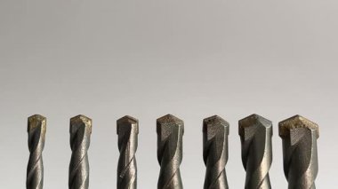 Yedi tungsten karbit uçlu matkap uçlarının beyaz arkaplana hizalanması: İnşaat araçları, donanım, mühendislik ve DIY onarım projelerini temsil eder