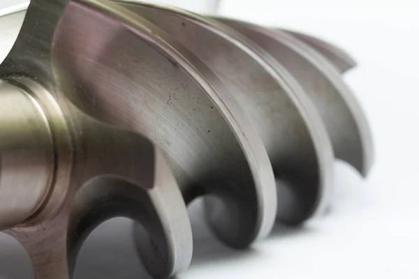 Endüstriyel kompresör veya vites pompasından çıkan metal helezon pervanesi kıvrımlı lobları, hassasiyet mekanizmasını vurguluyor.