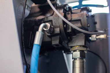 Parlak krom hidrolik pnömatik boru tesisatları ve çelik cıvatalar ağır, mekanik metalik manifold bloğuna bağlanmış, sıvı güç sistemlerini ve endüstriyel kaliteyi vurguluyor