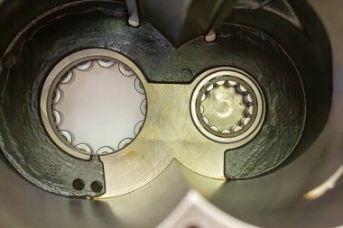 Parçalanmış endüstriyel kompresör ya da pompa yuvası, yağ ile yağlanmış iki büyük, hassas bilye ortaya çıkarıyor ve pervane desteği için metalik yatak koltukları monte