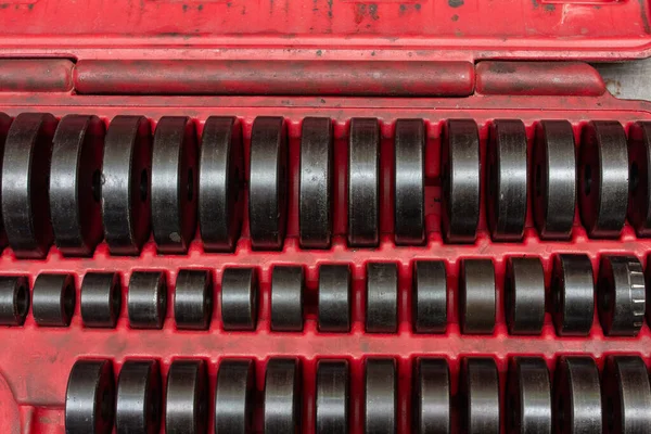 Rulman yüklemek veya kaldırmak için özel araç kiti, çeşitli boyutlarda koyu metalik baskı adaptörleri içeren satırlar parlak kırmızı plastik bir kutu içinde düzenli