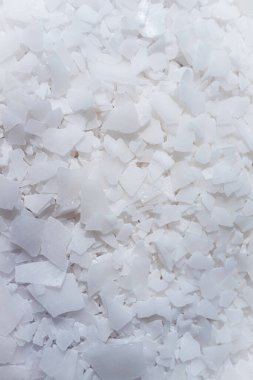 Beyaz arka planda magnezyum tuz tanelerinin yakın çekimi, detaylı beyaz parçacıklar deniz tuzu, doğal desen. Magnezyum terapisi, Sağlık Sigortası, kişisel bakım, sağlığın iyileştirilmesi, ev istirahatı.