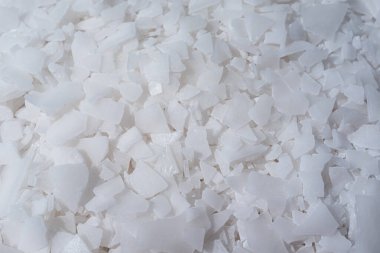 Beyaz arka planda magnezyum tuz tanelerinin yakın çekimi, detaylı beyaz parçacıklar deniz tuzu, doğal desen. Magnezyum terapisi, Sağlık Sigortası, kişisel bakım, sağlığın iyileştirilmesi, ev istirahatı.