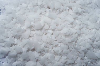Beyaz arka planda magnezyum tuz tanelerinin yakın çekimi, detaylı beyaz parçacıklar deniz tuzu, doğal desen. Magnezyum terapisi, Sağlık Sigortası, kişisel bakım, sağlığın iyileştirilmesi, ev istirahatı.
