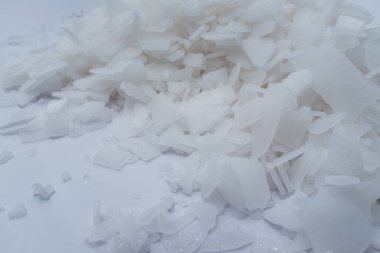 Beyaz arka planda magnezyum tuz tanelerinin yakın çekimi, detaylı beyaz parçacıklar deniz tuzu, doğal desen. Magnezyum terapisi, Sağlık Sigortası, kişisel bakım, sağlığın iyileştirilmesi, ev istirahatı.