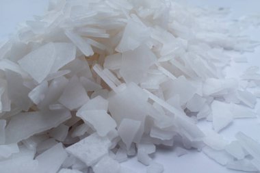 Beyaz arka planda magnezyum tuz tanelerinin yakın çekimi, detaylı beyaz parçacıklar deniz tuzu, doğal desen. Magnezyum terapisi, Sağlık Sigortası, kişisel bakım, sağlığın iyileştirilmesi, ev istirahatı.