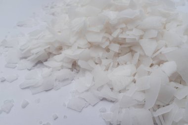 Beyaz arka planda magnezyum tuz tanelerinin yakın çekimi, detaylı beyaz parçacıklar deniz tuzu, doğal desen. Magnezyum terapisi, Sağlık Sigortası, kişisel bakım, sağlığın iyileştirilmesi, ev istirahatı.