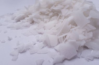 Beyaz arka planda magnezyum tuz tanelerinin yakın çekimi, detaylı beyaz parçacıklar deniz tuzu, doğal desen. Magnezyum terapisi, Sağlık Sigortası, kişisel bakım, sağlığın iyileştirilmesi, ev istirahatı.