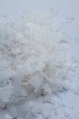 Beyaz arka planda magnezyum tuz tanelerinin yakın çekimi, detaylı beyaz parçacıklar deniz tuzu, doğal desen. Magnezyum terapisi, Sağlık Sigortası, kişisel bakım, sağlığın iyileştirilmesi, ev istirahatı.