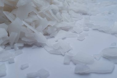 Beyaz arka planda magnezyum tuz tanelerinin yakın çekimi, detaylı beyaz parçacıklar deniz tuzu, doğal desen. Magnezyum terapisi, Sağlık Sigortası, kişisel bakım, sağlığın iyileştirilmesi, ev istirahatı.