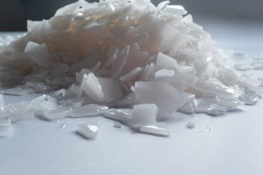 Beyaz arka planda magnezyum tuz tanelerinin yakın çekimi, detaylı beyaz parçacıklar deniz tuzu, doğal desen. Magnezyum terapisi, Sağlık Sigortası, kişisel bakım, sağlığın iyileştirilmesi, ev istirahatı.