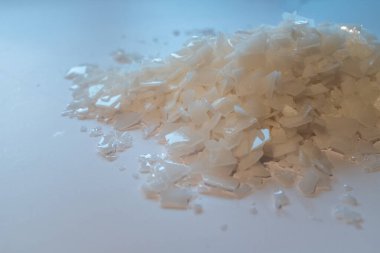 Beyaz arka planda magnezyum tuz tanelerinin yakın çekimi, detaylı beyaz parçacıklar deniz tuzu, doğal desen. Magnezyum terapisi, Sağlık Sigortası, kişisel bakım, sağlığın iyileştirilmesi, ev istirahatı.