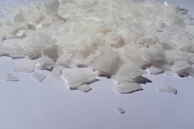 Beyaz arka planda magnezyum tuz tanelerinin yakın çekimi, detaylı beyaz parçacıklar deniz tuzu, doğal desen. Magnezyum terapisi, Sağlık Sigortası, kişisel bakım, sağlığın iyileştirilmesi, ev istirahatı.