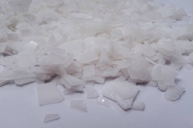 Beyaz arka planda magnezyum tuz tanelerinin yakın çekimi, detaylı beyaz parçacıklar deniz tuzu, doğal desen. Magnezyum terapisi, Sağlık Sigortası, kişisel bakım, sağlığın iyileştirilmesi, ev istirahatı.