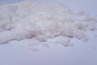 Beyaz arka planda magnezyum tuz tanelerinin yakın çekimi, detaylı beyaz parçacıklar deniz tuzu, doğal desen. Magnezyum terapisi, Sağlık Sigortası, kişisel bakım, sağlığın iyileştirilmesi, ev istirahatı.