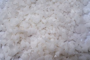 Beyaz arka planda magnezyum tuz tanelerinin yakın çekimi, detaylı beyaz parçacıklar deniz tuzu, doğal desen. Magnezyum terapisi, Sağlık Sigortası, kişisel bakım, sağlığın iyileştirilmesi, ev istirahatı.