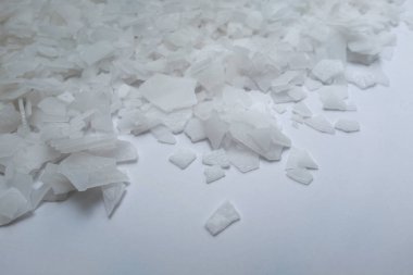 Beyaz arka planda magnezyum tuz tanelerinin yakın çekimi, detaylı beyaz parçacıklar deniz tuzu, doğal desen. Magnezyum terapisi, Sağlık Sigortası, kişisel bakım, sağlığın iyileştirilmesi, ev istirahatı.