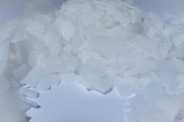 Beyaz arka planda magnezyum tuz tanelerinin yakın çekimi, detaylı beyaz parçacıklar deniz tuzu, doğal desen. Magnezyum terapisi, Sağlık Sigortası, kişisel bakım, sağlığın iyileştirilmesi, ev istirahatı.