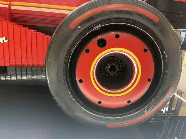 Modern bir sergi salonunda veya sergi ortamında hobi ve yaratıcı tasarım için kırmızı formüllü yarış arabası tekerleğinin yarış tekerine yakın çekimde lastik oyuncağı inşaatı