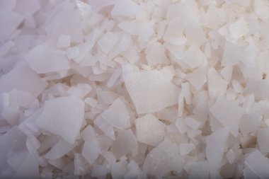 Beyaz arka planda magnezyum tuz tanelerinin yakın çekimi, detaylı beyaz parçacıklar deniz tuzu, doğal desen. Magnezyum terapisi, Sağlık Sigortası, kişisel bakım, sağlığın iyileştirilmesi, ev istirahatı.