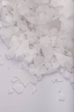 Beyaz arka planda magnezyum tuz tanelerinin yakın çekimi, detaylı beyaz parçacıklar deniz tuzu, doğal desen. Magnezyum terapisi, Sağlık Sigortası, kişisel bakım, sağlığın iyileştirilmesi, ev istirahatı.