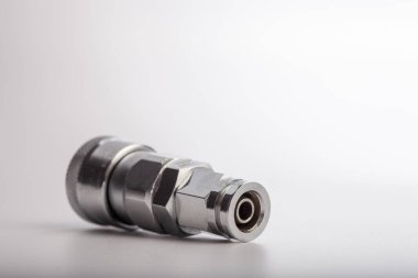 Açık gri arkaplana karşı pnömatik sistemler için paslanmaz çelik konnektörü