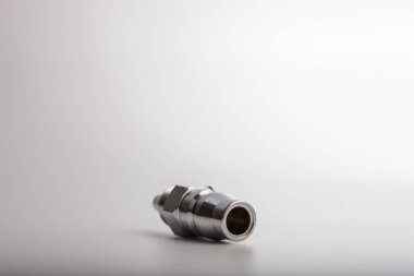 Açık gri arkaplana karşı pnömatik sistemler için paslanmaz çelik konnektörü