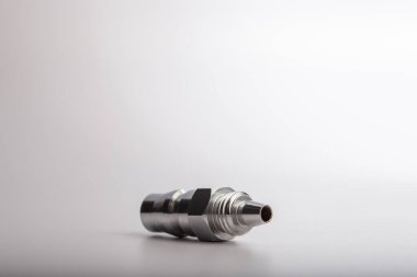 Açık gri arkaplana karşı pnömatik sistemler için paslanmaz çelik konnektörü