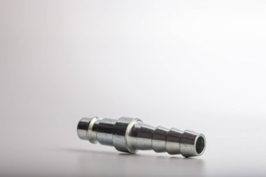 Açık gri arkaplana karşı pnömatik sistemler için paslanmaz çelik konnektörü