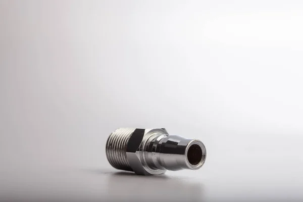 Açık gri arkaplana karşı pnömatik sistemler için paslanmaz çelik konnektörü