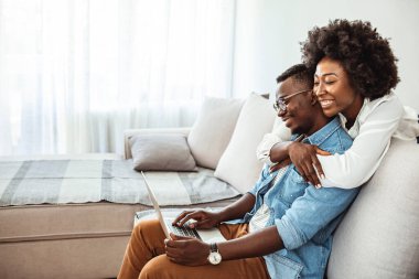 Mutlu Afrikalı çift dizüstü bilgisayar kullanıyor, internetten iyi haberler alıyor, e-posta alıyor, bankadan olumlu kararlar alıyor, karı-kocanın birlikte ekrana bakması, ipotek veya kredi onaylı kağıt mektubu.