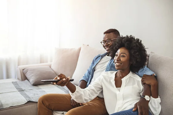 情侣们在家里看电视 年轻夫妇们在沙发上放松一下 聊着笑 换频道 上网冲浪 — 图库照片