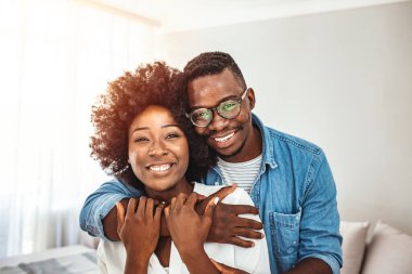 Birbirini kucaklayan çekici bir çiftin portresi. Çok ırklı çiftlerin kucaklaşması ve öpüşmesi. Neşeli erkek arkadaşın ve Afrikalı kızın evde birbirine sarılıp....