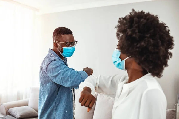 Business colleagues with face masks greeting with elbows during coronavirus pandemic. Elbow bump. Novel greeting to avoid spread of coronavirus. Practicing social distancing