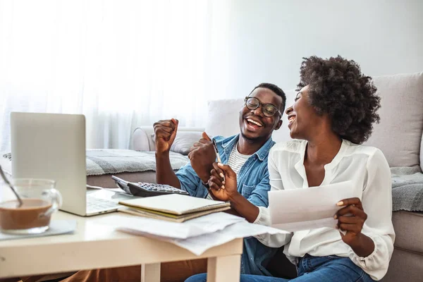 家族保険の概念 肯定的な黒のカップルは 契約の詳細を一緒にチェックし 自宅で文書を読む Sofaに座っている若いアフリカのカップル請求書の計算 — ストック写真