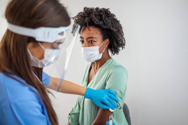 Pratisyen hekim eski hastayı özel klinikte fotokopi aletiyle aşılıyor. Hastanede kadına iğne yapan bir doktor. Covid-19 ya da Coronavirus aşısı yapmadan önce şırınga tutan ve pamuk kullanan hemşire..