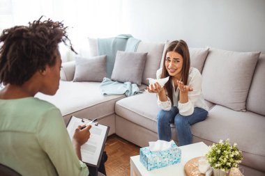 Genç Kadın Danışmanla Sorunları Tartışıyor. Psikoterapistle görüşürken yeme bozukluğu olan üzgün genç bir kadın. Ruh sağlığı uzmanı hastayı rahatlatıyor 