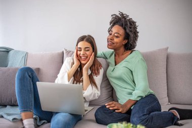 İki farklı arkadaş rahat kanepede rahatlıyor ve ev kablosuz interneti kullanarak dizüstü bilgisayarda film izliyorlar. Çok kültürlü genç kadınlar ortak bloglarında birlikte çalışıyorlar.