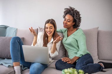 Kadınlar rahat bir dairede dizüstü bilgisayar kullanarak eğleniyorlar. Makyaj dersleri izleyip dışarı çıkmaya hazırlanıyorum. Kadın arkadaşlar evde eğleniyor, dizüstü bilgisayar kullanıyorlar.