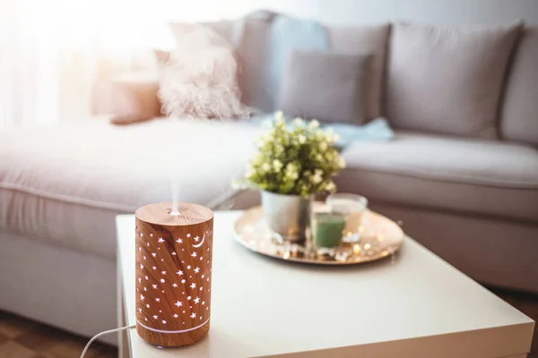 Essential oils diffusing at home in the morning light. Essential Oil Diffuser. Small air humidifier at home.  Aroma health essence, welness aromatherapy home spa fragrance tranquil theraphy, therapeutic steam