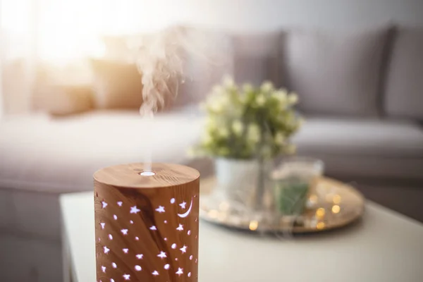 Essential oils diffusing at home in the morning light. Essential Oil Diffuser. Small air humidifier at home.  Aroma health essence, welness aromatherapy home spa fragrance tranquil theraphy, therapeutic steam