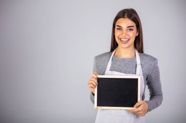 Küçük işletme sahibi kafesini ilk kez açmaya hazır. Kara tahtayı tutuyor. Üniformalı önlük giyen kadın işçi karatahta işareti taşıyor. Ticari reklam kurulunda çalışan bir organizatör.