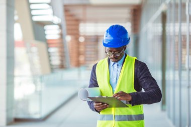 İnşaat alanında çalışan genç bir mühendis. Genç işadamı inşaat mühendisi, yakın plan. İnşaat alanında güvenlik ekipmanı mühendisi.